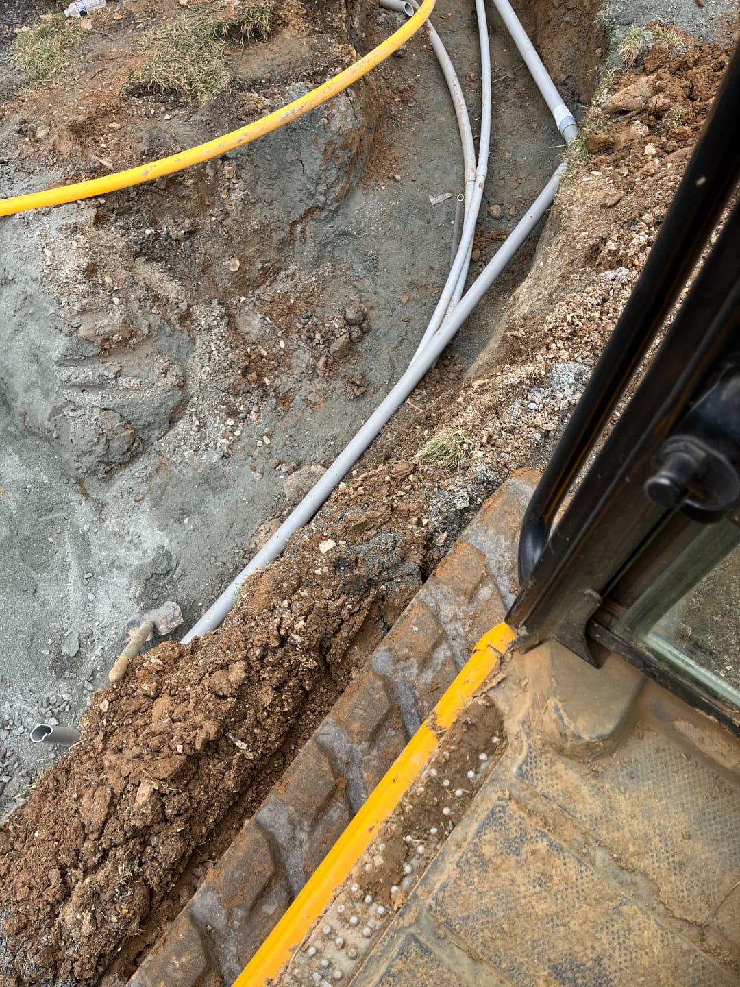 Underground conduit installation in an excavated trench for utility service